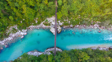 Aerial view of the turquoise blue Soca river (Isonzo) and wooden bridge near Bovec in the Julian Alps