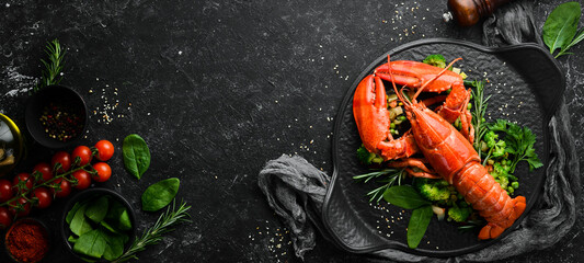 Boiled lobster with vegetables on a black stone plate. Seafood. Top view. Free space for your text.