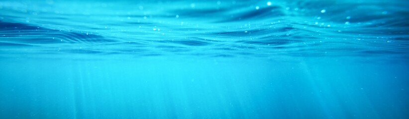 Picturesque panoramic underwater view. Sunbeams in turquoise water. Abstract natural texture, pattern, background, wallpaper, graphic resource. Sea, river, lake, pure nature, environment