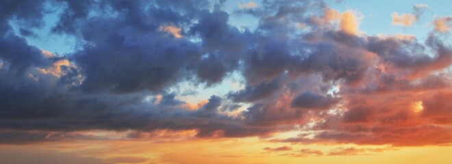 Epickie ciemne niebo o zachodzie słońca nad brzegiem morza po burzy. Dramatyczne świecące kolorowe czerwone chmury.