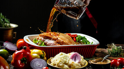Roasted knuckle of pork with the addition of beer. Oktovber recipe for festival. banner, menu recipe. a chef hands preparing bavarian pork knuckle