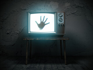 Horror scary movie concept. Hand of ghost on screen of vintage tv in haunted house.
