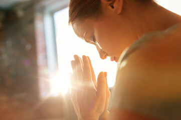 religion, faith and people concept - close up of woman meditating at yoga studio