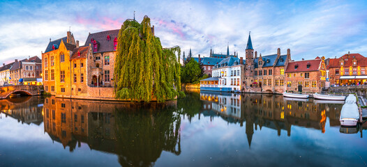 Sunset panorama Brugge city centre, often referred to as The Venice of the North, with famous Rozenhoedkaai illuminated in beautiful twilight, West Flanders province, Belgium