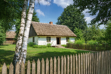 Wiejski domek drewniany ze strzechą na dachu