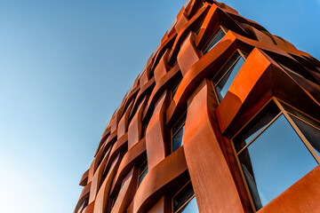 The facade of a stylish business building with modern architecture against a blue sky