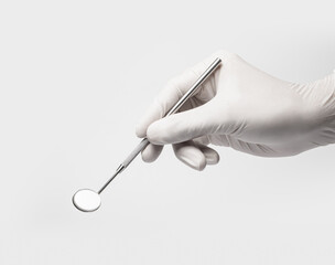 Dental mirror tool in dentist hand on white backgroud