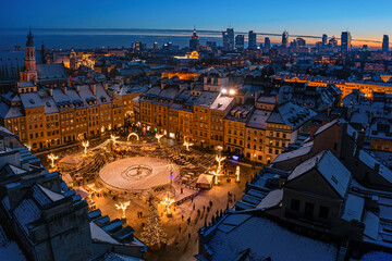 Warszawa, rynek starego miasta udekorowany świątecznym oświetleniem, widok z lotu ptaka na ośnieżone budynki i centrum miasta w oddali