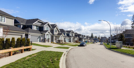 Residential neighborhood Street in Modern City Suburbs. Sunny Winter Day. Fraser Heights, Surrey, Greater Vancouver, British Columbia, Canada.