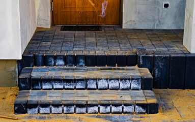 Schody i tarasik oraz chodnik z kostki brukowej i betonowych palisad , brukowanie i brukarstwo . Widoczne , białe , wykwity wapienne które występują na nowo ułożonych kostkach betonowych .