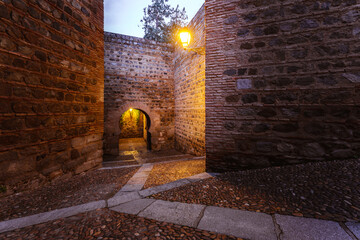 Narrow street. Rear view of Puerta de Alcantara, historical landmark in Toledo, Spain