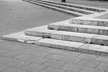 Modernistyczne schody na placu/rynku w czerni i bieli. Proste linie, beton, krajobraz miejski.