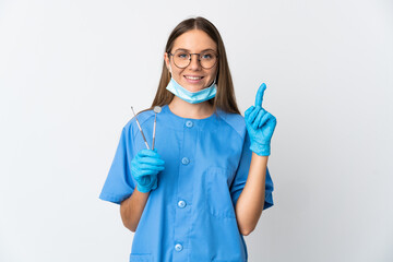 Lithuanian woman dentist holding tools over isolated background pointing up a great idea