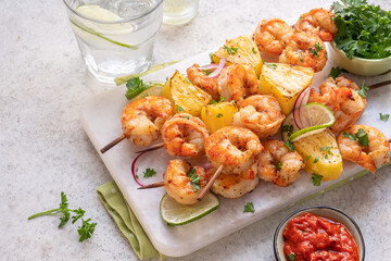 kebab skewers of barbecued shrimp with a pineapple