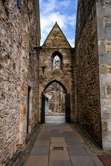 Vertical shot of an old European castle's gate with metal doors and arch.