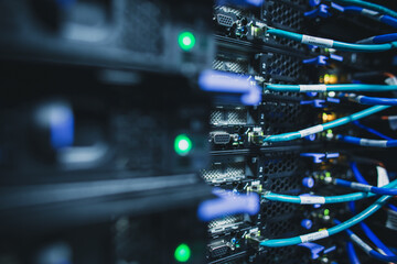 IT engineer standing before working server rack doing routine maintenance check and diagnostics using laptop
