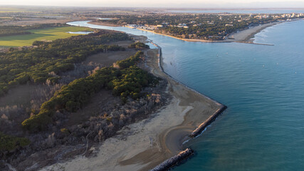 Aerial shot of the beach of Bibione, Venice. Crystal clear water and white rocks. Golden beach and circular shapes. Heaven on earth in Italy, near the Tagliamento river.