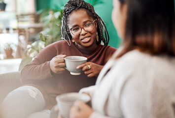 Coffee, the official drink of girls night in. two young women having coffee and chatting on the sofa at home.