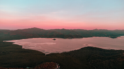 Piękny zachód słońca, kolorystyka różowo pomarańczowa, tropikalne wyspy i ocean.