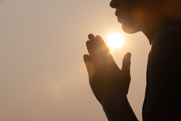 Silhouette of woman prayer position, Praying hands with faith in religion and belief in God on dark background. Power of hope or love and devotion. Namaste or Namaskar hands gesture.