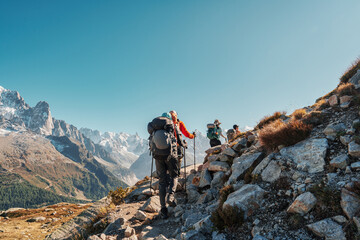 Group of hiker hiking with difficult on mountain trail amidst French alps on sunny day at France