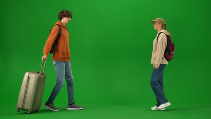 Portrait of person tourist isolated on chroma key green screen background. Young couple meets at the arrival area, man and girl smiling happy expression.