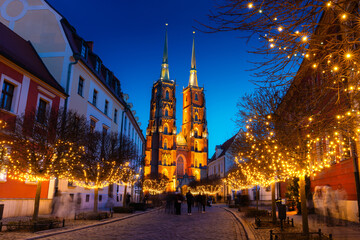 Street with cobblestone road, lights on trees, St. John the Baptist Cathedral, Wroclaw, Poland