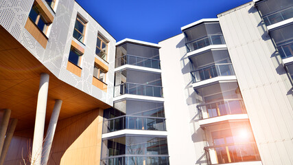 A apartment building with a unique architectural solution. A modern residential building with a white facade and standing on high concrete pillars.