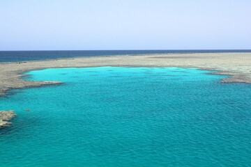 Captivating view of Egypt's Red Sea coral reef near Marsa Alam, Hamata Islands. Crystal-clear turquoise waters under a warm, sunny sky.