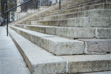 Zbliżenie na granitowe, wysokie miejskie schody. Ujęcie z boku. Miejsce na tekst.