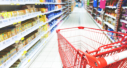 Baner reklamowy, rozmazane tło, background, wnętrze sklepu, supermarketu, wózek sklepowy,, półki sklepowe z produktami. Miejsce na tekst.