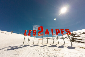 Town in the alps mountains during sunset. Aerial drone photo. French alps in winter, Rhone Alpes in France Europe . Les deux alpes village in spring time. Winter French Alpes town from drone.