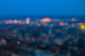 Defocused photo of big city during beautiful blue hour with city and street lights glowing colorfully.