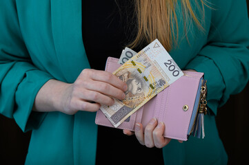 Szukać pieniędzy w portfelu. Trzymać polskie banknoty pln w dloniach