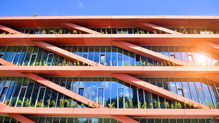 Modern office building with glass facade on a clear sky background. Transparent glass wall of office building.