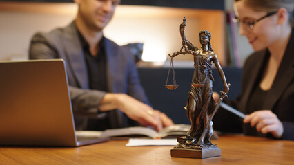 A lawyer meets with a new client. A young male lawyer in a suit sits at an office desk, shares legal advice, explains the inheritance process, tries to help. Legal advice concept