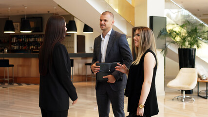 Business woman assistant director meets investors. Business people meeting in the lobby of a modern corporate office for a business meeting.