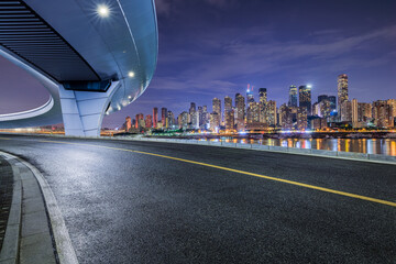 Asphalt road and bridge with modern city buildings at night in Chongqing. car background.