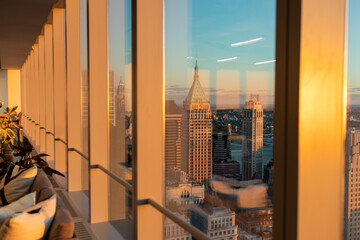 view of downtown manhattan from conference room of skyscraper at golden hour