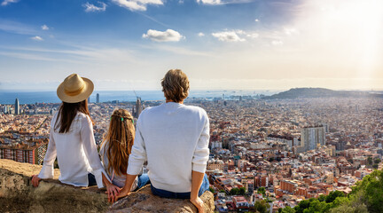 A tourist family enjoys the panoramic view of the skyline of Barcelona, Spain, during their city trip vacation