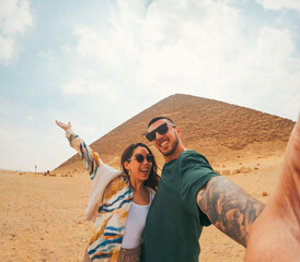 Happy tourists couple taking selfie in front of the red pyramid, dahshur, egypt