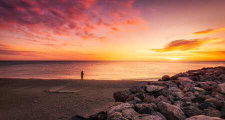 dramatic coastal landscape with colorful dramatic sky with person