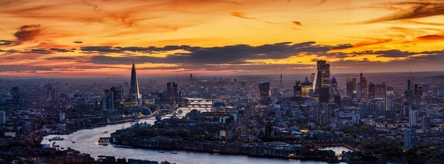 Beautiful, panoramic view of the 2025 London skyline just after sunset with city lights and colorful cloudscape