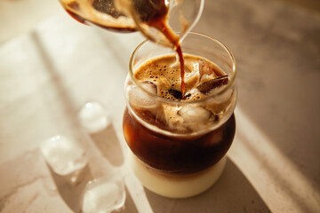 This iced coffee layers rich espresso over milk with melting ice cubes, perfect for slow mornings, coffee rituals, and lifestyle visuals.