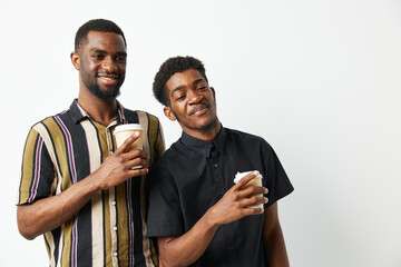 Two black men enjoying coffee together, smiling brightly in casual clothing. Capturing friendship and joy in a relaxed setting, ideal for lifestyle themes.
