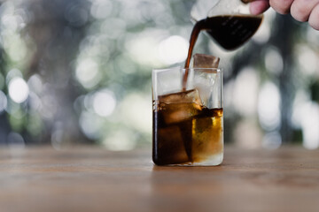 Iced americano coffee, an espresso coffee short pouring on water with iced cubes in a transparent glass