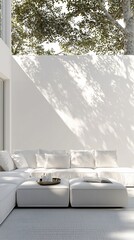 Serene white living room with sun-dappled wall and plush white sectional sofa