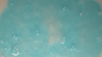 Abstrakcyjne tło w kolorach niebieskich i beżowych z widocznymi bąbelkami na powierzchni tekstury