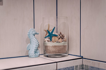 Dekoracja morska z muszlami i rozgwiazdą w szklanym naczyniu