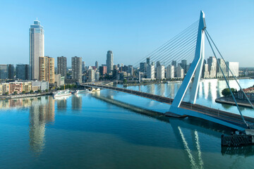 Maas River with Erasmus Bridge in Rotterdam, the Netherlands high rise buildings Zalmhaventoren with reflection of buildings and bridge in tranquil waters of river